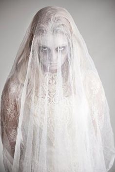 a woman wearing a veil and white dress