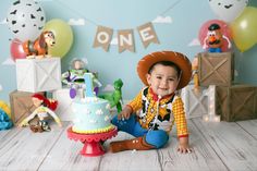 a little boy sitting in front of a birthday cake