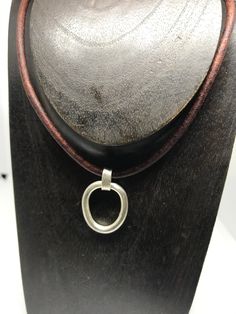 "A thick, 8 gauge, sterling link dangles from a leather necklace. Finished with handmade links and a fish hook clasp. A tiny sterling peace charm completes the necklace. Total length is 21\". The link is approx. 1x3/4\". The link drop is 1 1/4\"including the bail. Leather is 3mm,naturally dyed brown." Everyday Silver Leather Necklace, Silver Leather Dangle Jewelry, Hook Clasp, Naturally Dyed, Leather Necklace, Fish Hook, Necklace Etsy, Jewelry Necklaces, Dye