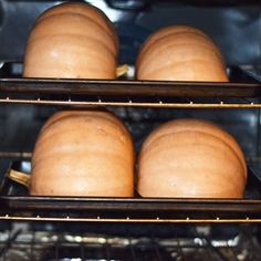 three pumpkins sitting in an oven on racks