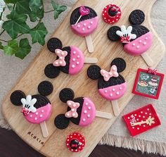 mickey and minnie mouse cupcakes on a wooden tray