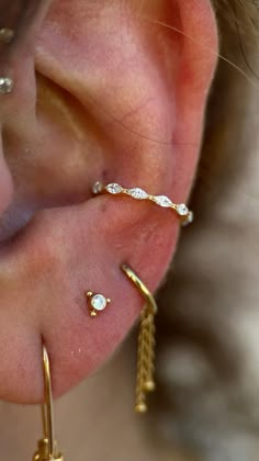 a close up of a person's ear with three different types of piercings