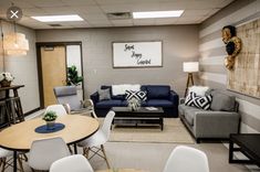 a living room with couches, chairs, tables and pictures hanging on the wall