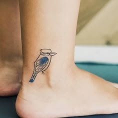 a small blue bird tattoo on the ankle