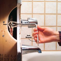 a person's hand is holding onto a faucet