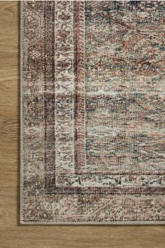 an area rug with wood flooring in the background and a wooden wall behind it