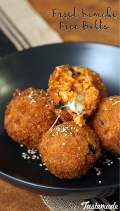 some fried food is sitting on a black plate with sprinkles and seasoning