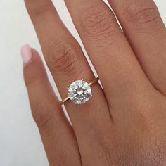 a woman's hand with a ring on it and a diamond in the middle