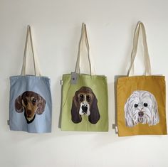 three bags with dogs on them hanging from hooks