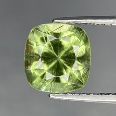 a large green diamond sitting on top of a piece of metal