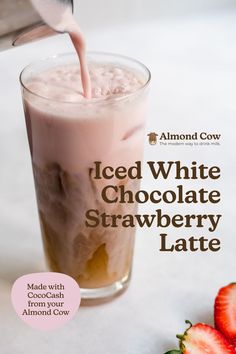 iced white chocolate strawberry latte is being poured into a glass with strawberries on the side