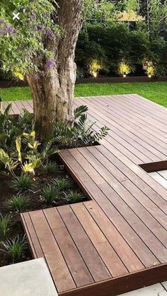 a wooden deck surrounded by plants and trees