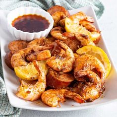 grilled shrimp with lemon wedges and ketchup on a white platter