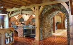 a kitchen with an oven, stove and brick wall in the middle of it's floor