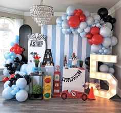 a room filled with balloons and decorations for a race car themed birthday party or baby's first birthday