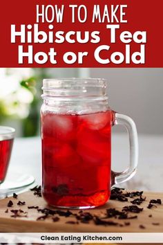 a mason jar filled with red liquid sitting on top of a wooden cutting board