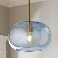 a light that is hanging from a ceiling in a room with a white wall and window