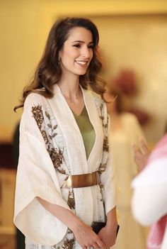 a woman is smiling and wearing a white robe