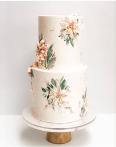 a three tiered cake with flowers painted on it