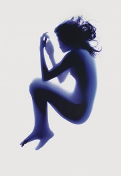 the silhouette of a naked woman is shown against a white background and blue hues