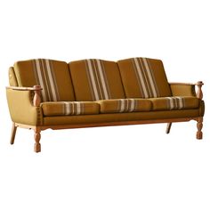 a brown and tan striped couch sitting on top of a wooden frame