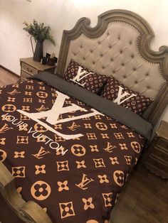 a bed with louis vuitton sheets and pillows