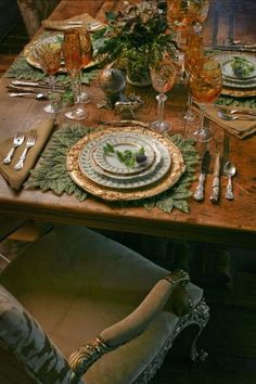 the table is set with plates, silverware and green napkins for dinner guests