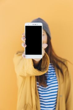 a woman holding up a smart phone in front of her face