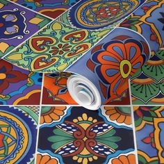 colorful tiles with different designs on them and a roll of paper in the middle one