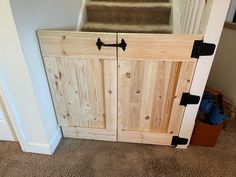 a wooden cabinet sitting in the corner of a room next to a stair case and carpeted floor