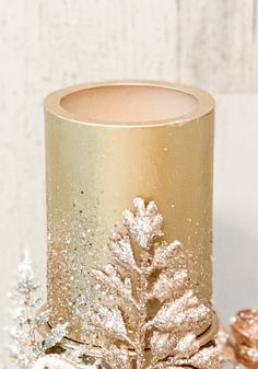 a gold and white candle holder sitting on top of a table next to other decorations