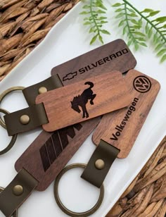 two wooden keychains sitting next to each other on top of a white plate