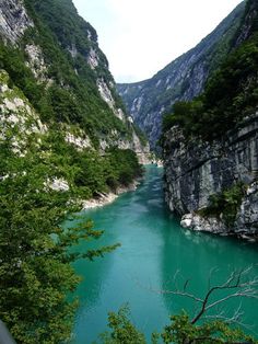 a river flowing through a valley surrounded by mountains