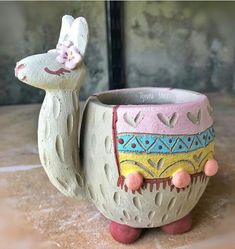 a ceramic animal shaped cup sitting on top of a table