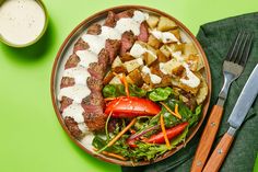 a plate with meat, potatoes and vegetables on it next to a glass of milk