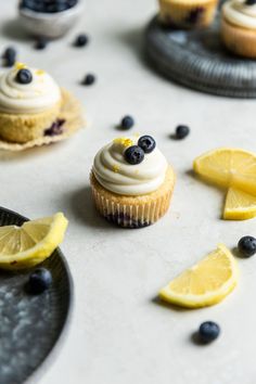 cupcakes with blueberries and lemon slices on the side, surrounded by other dessert items