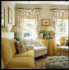 a living room filled with furniture and yellow drapes on the window sills