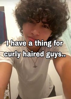 a man with curly hair is looking at the camera