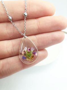 WILDFLOWER NECKLACE Handmade women's necklace with thin stainless steel chain, resistant and hypoallergenic, with small balls. Pendant with drop-shaped pendant in silver brass with transparent UV resin and inside purple real flowers and green leaves, dried pressed and vitrified in UV resin Pendant size: 2.5cmx2cm N.b. Customize and choose the size of the chain Wildflower Necklace, Flowers Pressed, Feminine Jewelry, Women's Necklace, Drop Pendant Necklace, Resin Flowers, Resin Pendant, Uv Resin, Drop Pendant