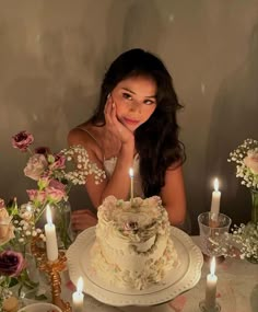 a woman sitting at a table in front of a cake