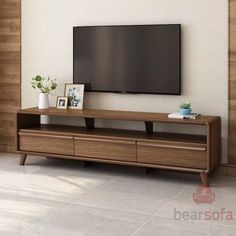 a flat screen tv sitting on top of a wooden entertainment center in a living room