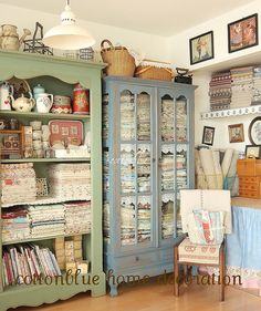 a room filled with lots of furniture and pictures on the wall next to a china cabinet