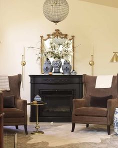 a living room filled with furniture and a fire place in front of a mirror on the wall