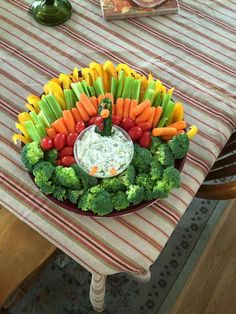 a platter filled with veggies and dip sits on a dining room table