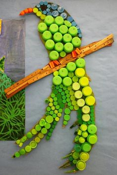 a child's artwork made out of buttons and pencils is displayed on the table