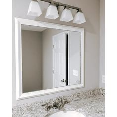 a bathroom with a sink, mirror and lights