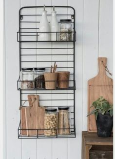 a metal shelf filled with lots of food next to a cutting board and potted plant