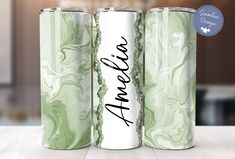 three green and white canisters with the word amer written in black ink