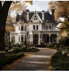 a large white house surrounded by trees and pumpkins