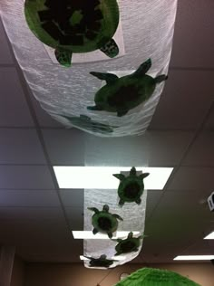 some green decorations hanging from the ceiling in an office cubicle with turtles on them